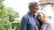 Portrait of mature couple standing in garden in front of dream home in countryside