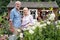 Portrait Of Mature Couple Working In Flower Beds In Garden At Home