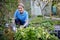 Portrait Of Mature Female Landscape Gardener Planting Plants In Garden