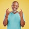 Portrait of a mature friendly african american man looking happy and smiling while making an rock on hand gesture