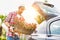 Portrait of mature gardener putting flowers on car trunk for delivery