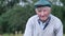 Portrait of a mature grandfather in a cap looking at the camera.