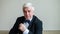 Portrait of a mature gray-haired smiling man in a suit and bow-tie. An elegantly dressed, clean-shaven senior looks