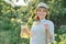 Portrait of mature happy woman in hat in the garden with natural homemade herbal drink with mint strawberries