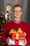 Portrait of mature man holding stack of Christmas presents