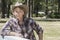 Portrait of a mature man wearing cowboy hat leaning on wooden slab