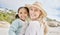 Portrait of a mature mother and her biracial innocent little daughter smiling and standing on the beach smiling. A happy