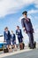 Portrait of mature pilot walking with three young beautiful flight attendants against airplane in airport