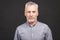 Portrait of a mature serious businessman isolated against black background. Happy senior man looking at camera with copy space.