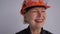 Portrait of a mature woman builder in a helmet. The profession is a civil engineer or an architect. Smiling professional