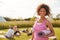 Portrait Of Mature Woman On Outdoor Yoga Retreat With Friends And Campsite In Background