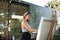 Portrait of mature woman with pallete painting outdoors in garden.