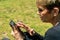 Portrait of mature woman reading message on smartphone outdoor. Senior woman reading message on the phone at park