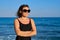 Portrait of mature woman in sunglasses swimsuit enjoying sea sunset