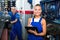 Portrait of mechanic girl in coveralls having cardboard with documents in hands