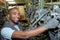 Portrait mechanic hanging up car parts in storage