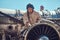 Portrait of a mechanic in uniform and flying helmet, repairing the dismantled airplane turbine in an open-air museum.