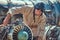 Portrait of a mechanic in uniform and flying helmet, repairing the dismantled airplane turbine in an open-air museum.