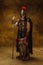 Portrait of medieval person, brutal man, warrior or knight in war equipment isolated on vintage dark background