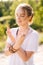 Portrait of meditating woman standing with closed eyes holding hands in yoga mudra.