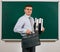 Portrait of a men dressed in business suit with folders, documents and briefcase, posing at blackboard background - learning and