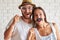 Portrait of merry couple holding paper bow-tie and glasses