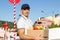 Portrait of mid adult deliveryman carrying box with products