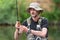 Portrait of mid adult fisherman on river, relaxing and fishing trouts.