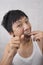 Portrait of mid adult man flossing his teeth in bathroom