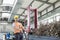 Portrait of mid adult worker pulling hand truck loaded with steel shavings in factory