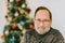 Portrait of middle age man posing next to Christmas tree