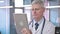 Portrait of Middle Aged Doctor Scrolling on Tablet