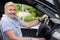 Portrait middle aged male driver behind wheel