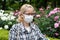 Portrait of middle aged mixed race blonde woman with eyeglasses wearing white surgical mask