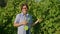 Portrait of middle aged woman gardener farmer in vineyard with tool for tying vine