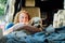 Portrait of middle-aged woman hugging her cockapoo puppy pet while sitting in van camper car vehicle during road trip