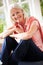 Portrait Of Middle Aged Woman Sitting On Window Seat