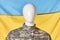 Portrait of military mannequin against ukrainian flag background.