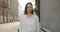 Portrait of millennial pretty woman turning head and looking to camera. Charming girl in white shirt posing while