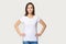 Portrait of millennial woman demonstrating white t-shirt for copyspace