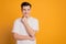 Portrait of minded happy young man dreaming look empty space isolated over yellow background