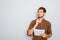 Portrait of minded man with notebook  on gray background