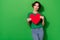 Portrait of minded pretty lady hold big heart postcard look empty space isolated on green color background