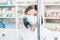 Portrait of a minority group doctor or pharmacist with mask on looking through a protective screen shield