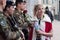 Portrait of miss of carnival speaking to military people with a red rose in hand