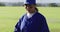 Portrait of mixed race female baseball player wearing eye black, throwing ball into glove