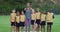 Portrait of mixed race female teacher and diverse group of schoolchildren smiling embracing outdoors