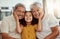 Portrait of mixed race grandparents enjoying weekend with granddaughter in home living room. Smiling hispanic girl