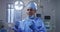 Portrait of mixed race male surgeon wearing lowered face mask smiling in operating theatre