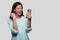 Portrait of a mixed race woman celebrating, excitement, ecstatic news, holding smartphone,  on white background